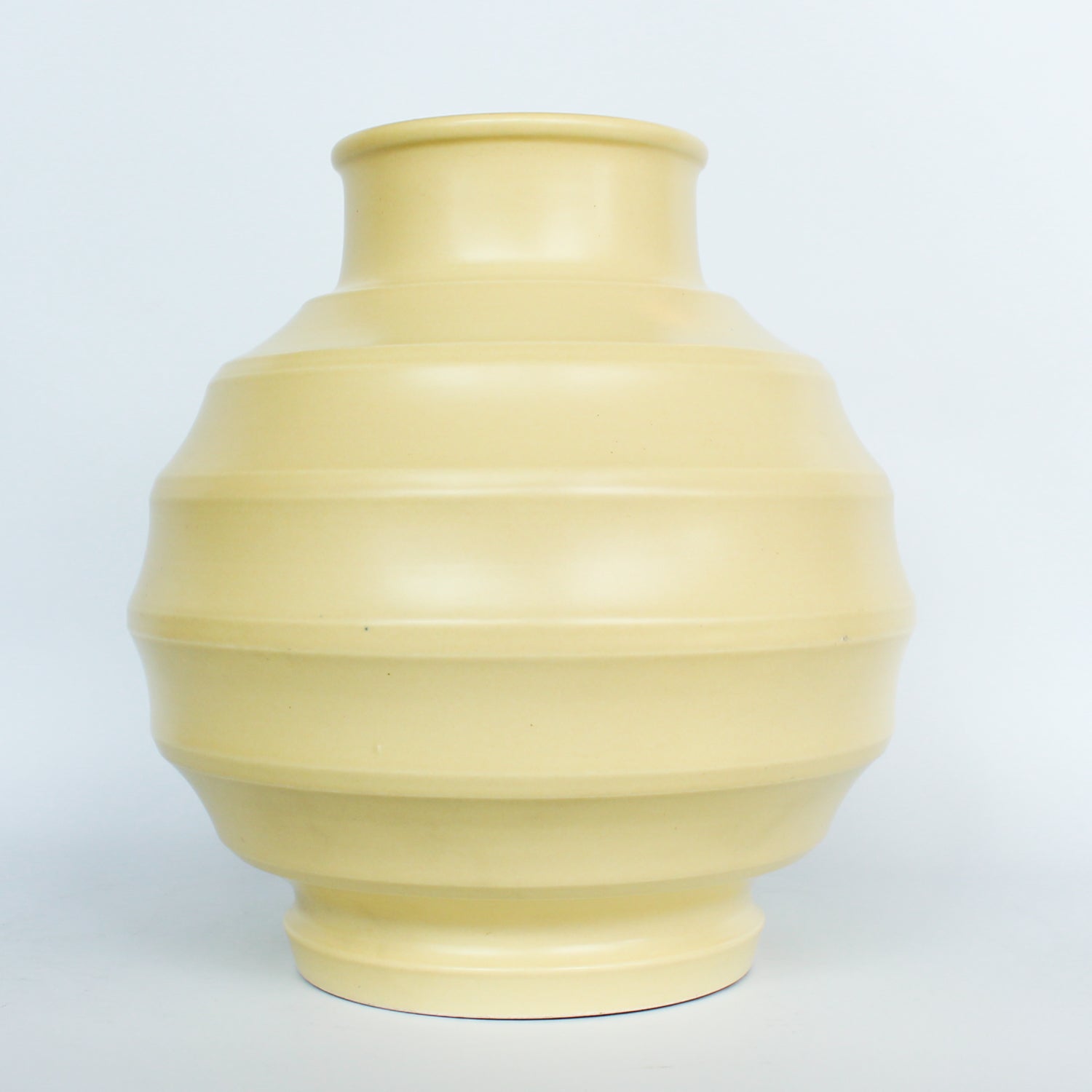 A Keith Murray design vase for wedgewood , sometimes known as football vase with deep horizontal ribs in a cream glaze. Full signature underneath at Jeroen Markies.
