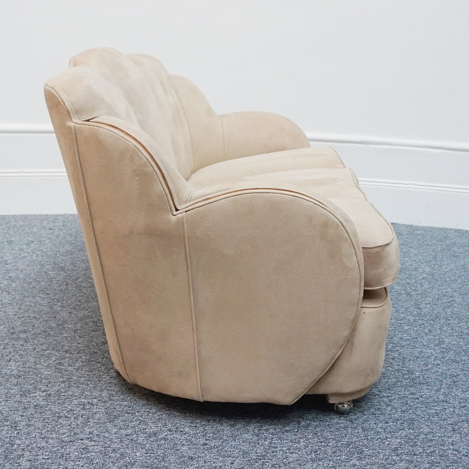 An Art Deco cloud back sofa by Harry & Lou Epstein with figured walnut banding to the arms and upholstered in cream faux suede