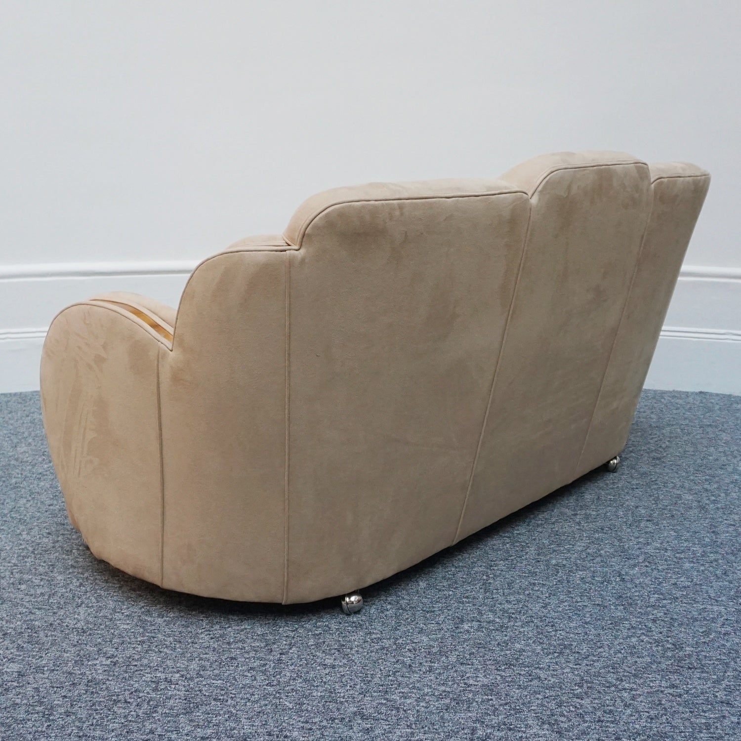 An Art Deco cloud back sofa by Harry & Lou Epstein with figured walnut banding to the arms and upholstered in cream faux suede