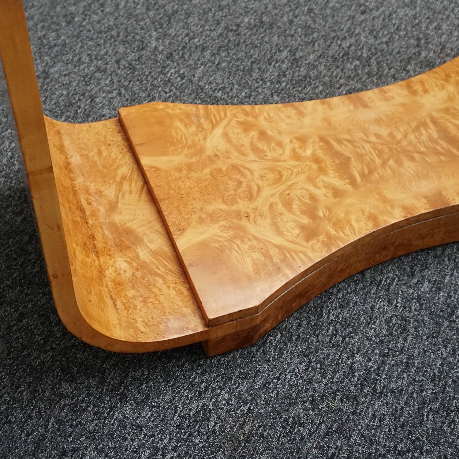 An art deco dining table with 6 chairs by Harry & Lou Epstein. The table top and cloud back armchairs are veneered in burr walnut. The chairs are upholstered in cream faux suede.