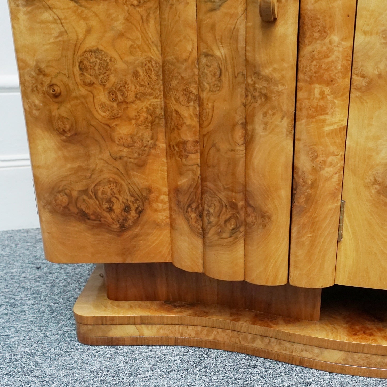 An Art Deco Sideboard by Harry & Lou Epstein with fluted sides set over a curved walnut base made of solid mahogany with burr walnut veneer