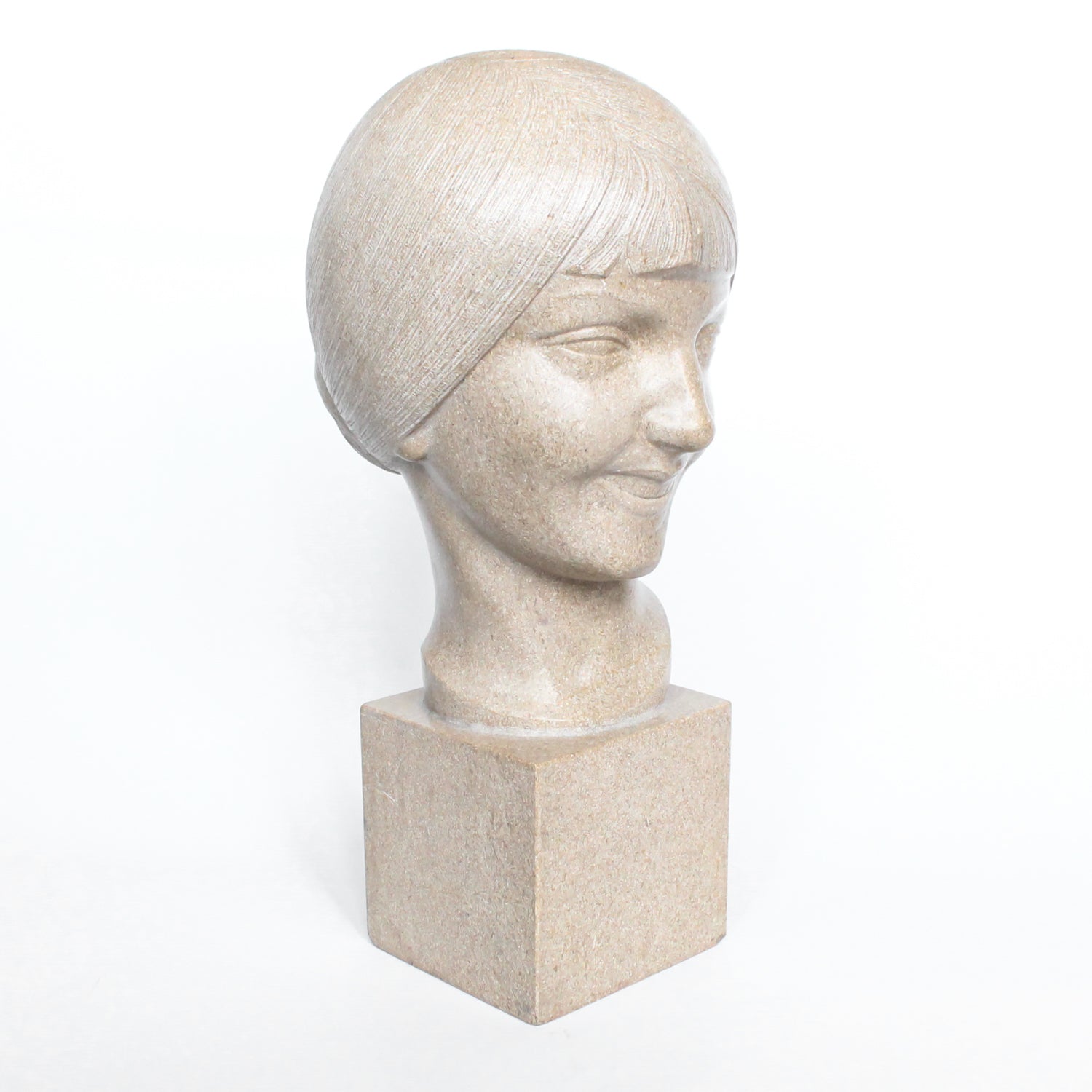 An Art Deco, stone carved sculpture of a smiling young lady, set over an integral plinth. Original dedication plaque to rear at Jeroen Markies.