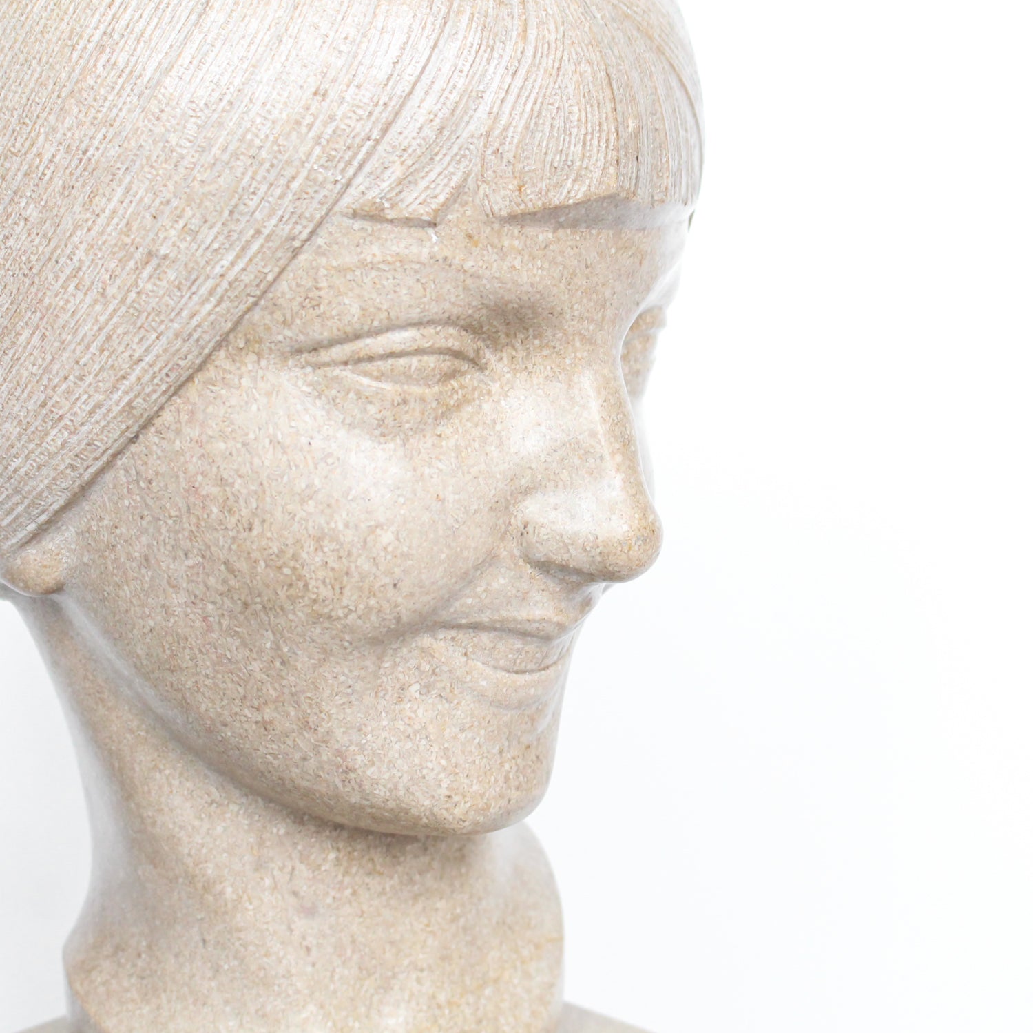 An Art Deco, stone carved sculpture of a smiling young lady, set over an integral plinth. Original dedication plaque to rear at Jeroen Markies.