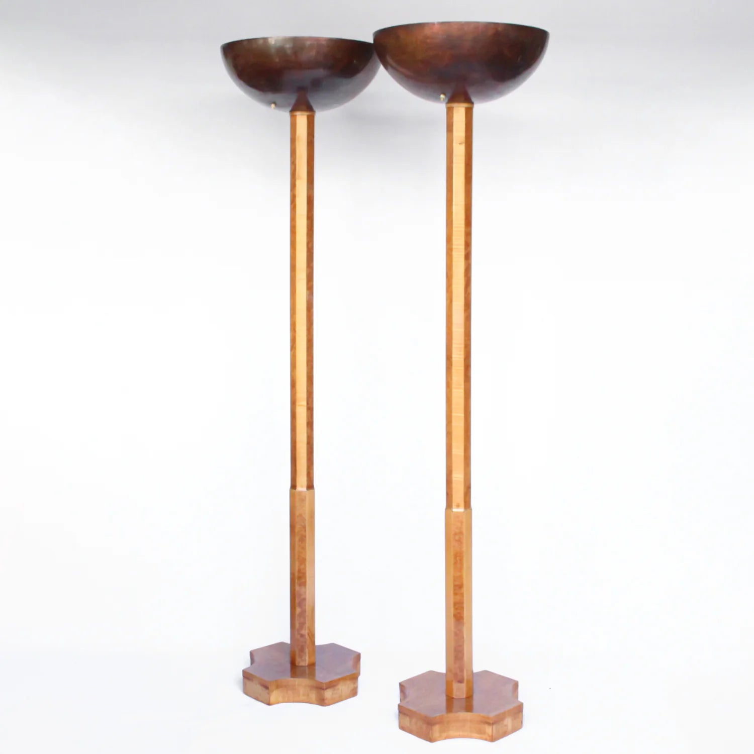 A pair of Art Deco uplighter floor lamps by Harry & Lou Epstein. Made of walnut and satin wood with domed copper shades.