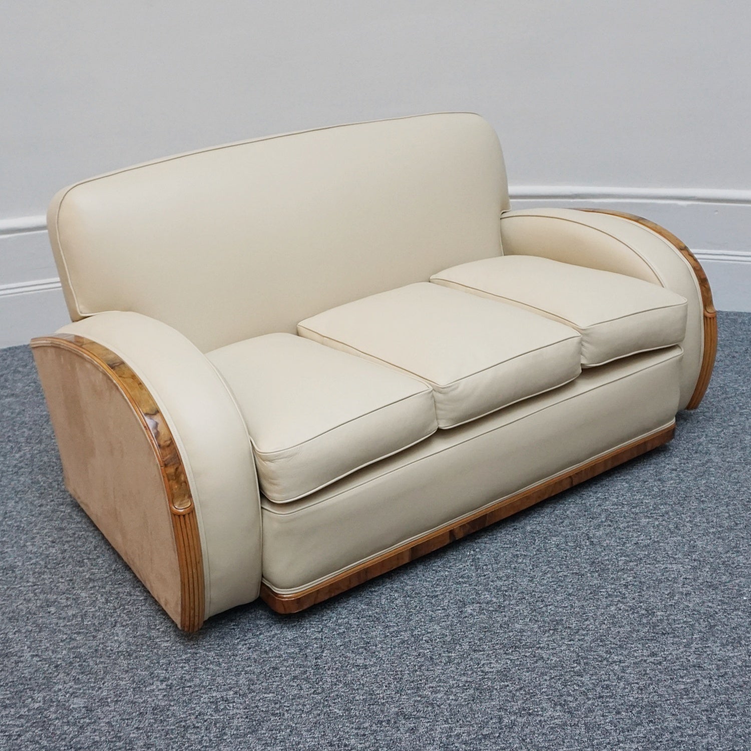 An Art Deco three piece tank suite by Heals of london. Made of Burr and solid walnut banding with reeded lower section, Upholstered in cream leather and contrasting faux suede