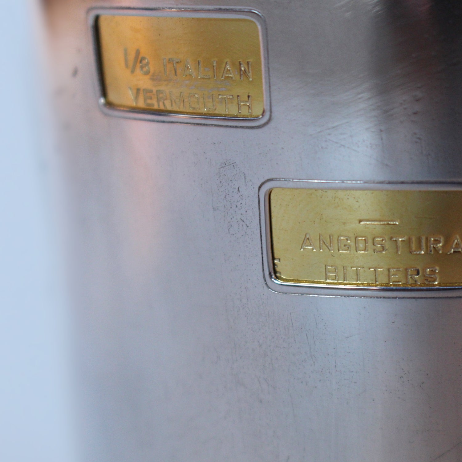 An Art Deco, silver plated and gilt recipe cocktail shaker. Integral strainer. Outer  sliver plated cover revealing brass underlayer with ingredients for various cocktails. Stamped 'Napier' to underside at Jeroen Markies.