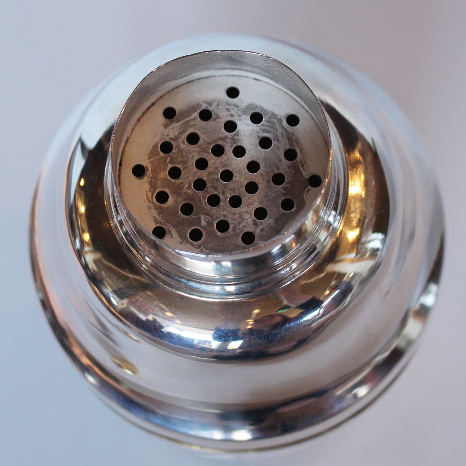 An Art Deco, silver plated and gilt recipe cocktail shaker. Integral strainer. Outer  sliver plated cover revealing brass underlayer with ingredients for various cocktails. Stamped 'Napier' to underside at Jeroen Markies.