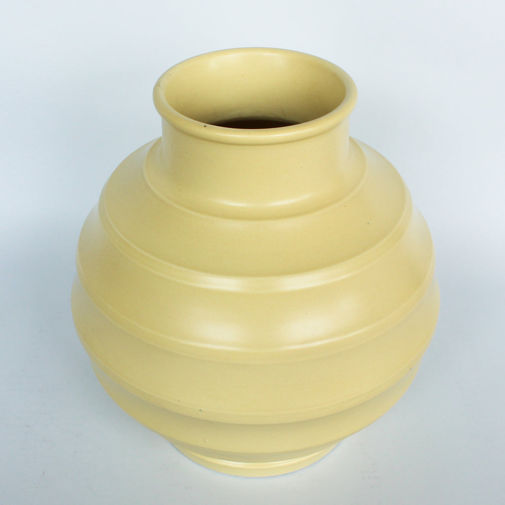 A Keith Murray design vase for wedgewood , sometimes known as football vase with deep horizontal ribs in a cream glaze. Full signature underneath at Jeroen Markies.
