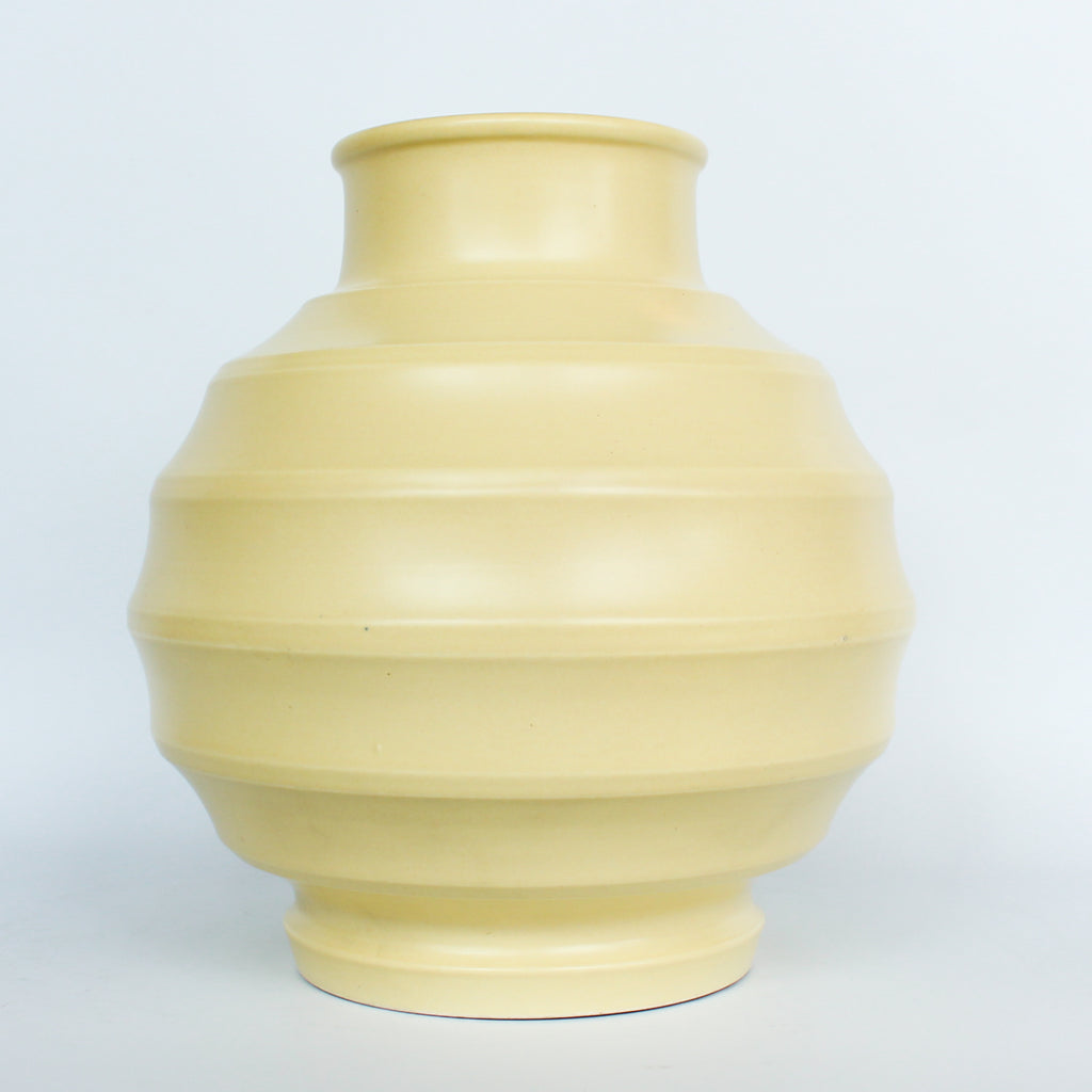 A Keith Murray design vase for wedgewood , sometimes known as football vase with deep horizontal ribs in a cream glaze. Full signature underneath at Jeroen Markies.