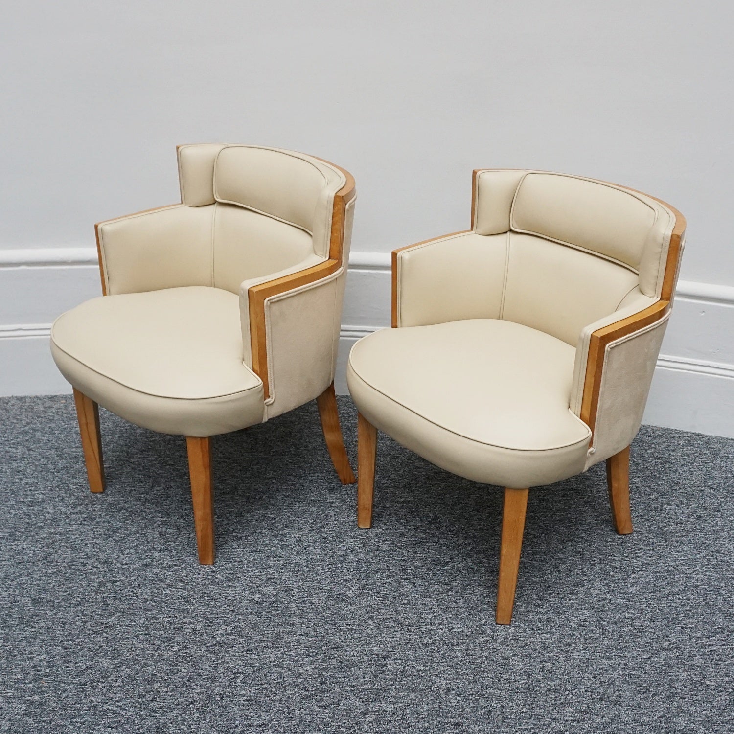 A pair of Art Deco bankers chairs birdseye maple veneered with solid satin birch legs. Upholstered in cream leather and contrasting oatmeal faux suede.