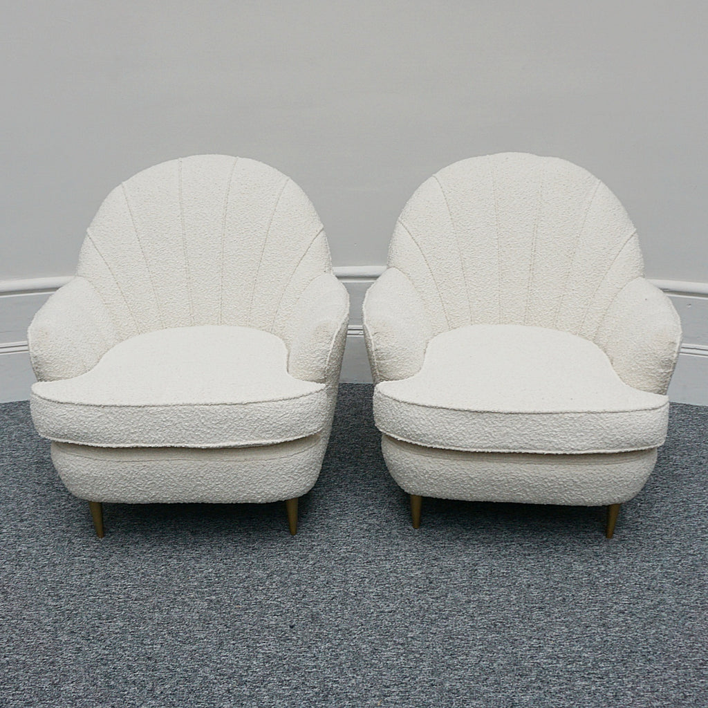 A pair of Mid Century lounge chairs upholstered in white Bouclé with metal and brass capped feet. Designed by Gigi Raddice for Minotti. 