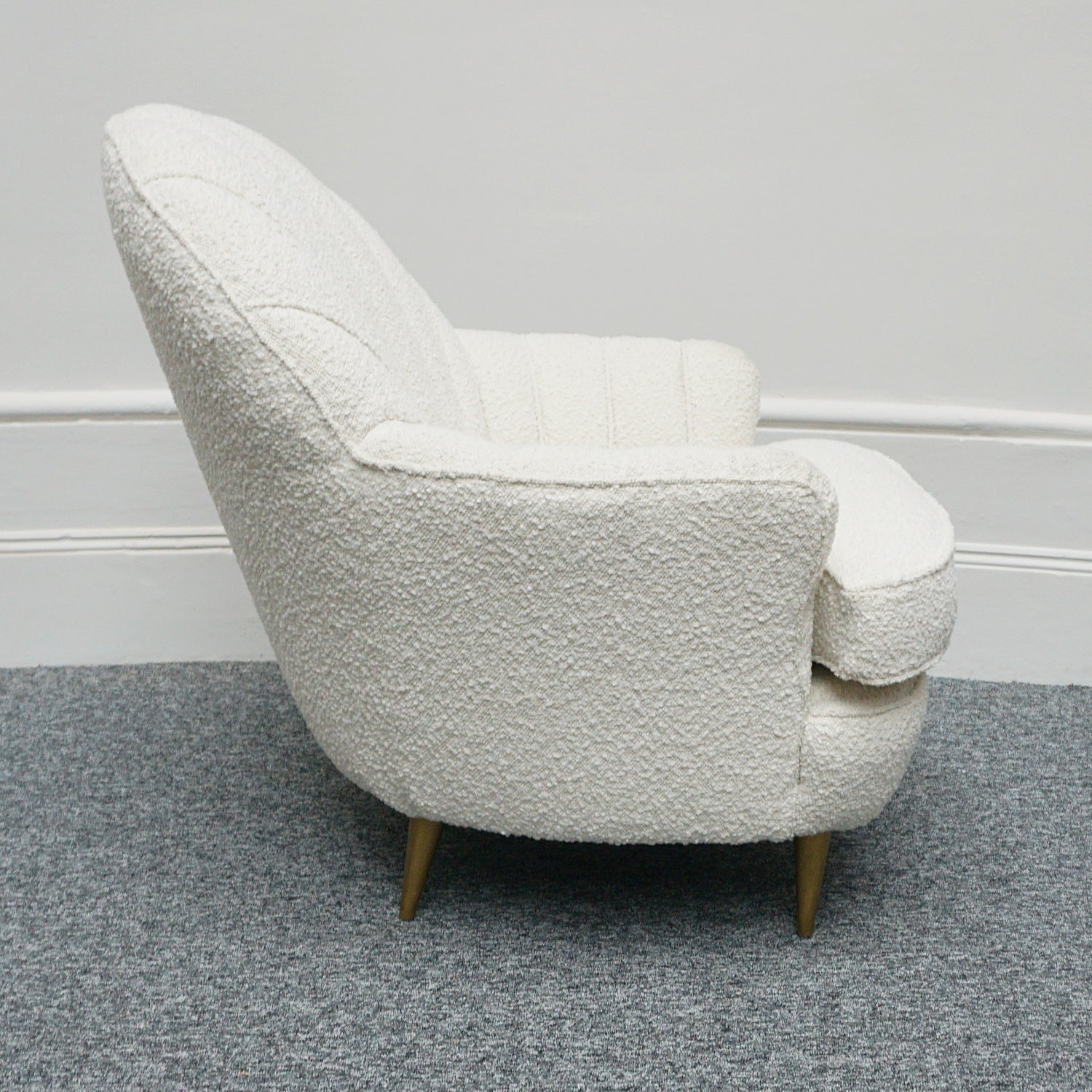 A pair of Mid Century lounge chairs upholstered in white Bouclé with metal and brass capped feet. Designed by Gigi Raddice for Minotti. 