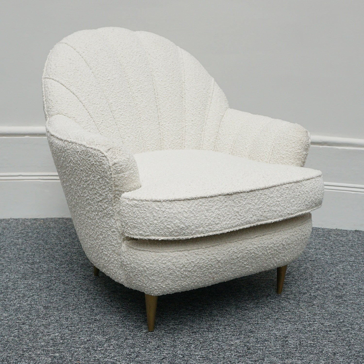 A pair of Mid Century lounge chairs upholstered in white Bouclé with metal and brass capped feet. Designed by Gigi Raddice for Minotti. 