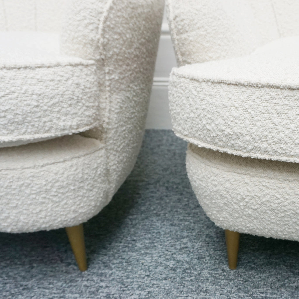 A pair of Mid Century lounge chairs upholstered in white Bouclé with metal and brass capped feet. Designed by Gigi Raddice for Minotti. 