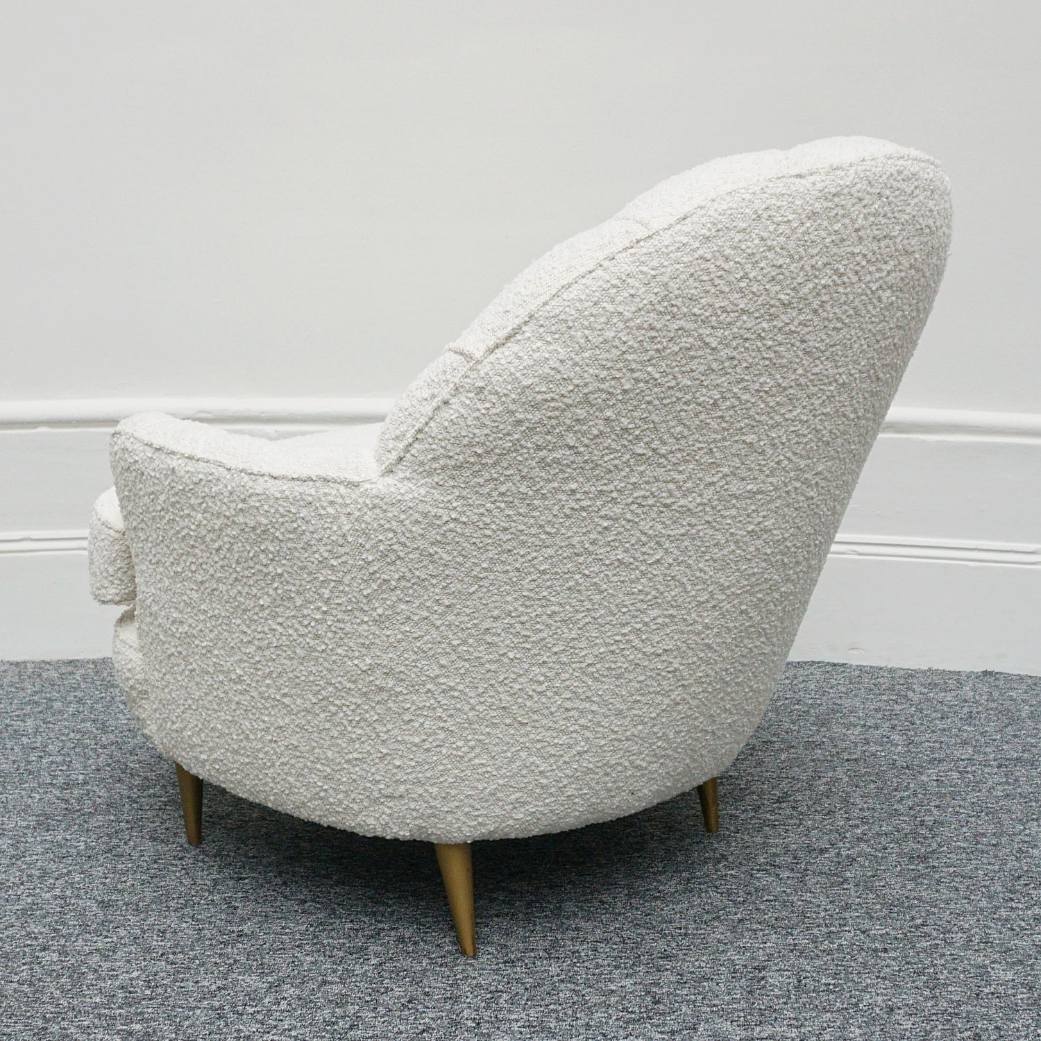 A pair of Mid Century lounge chairs upholstered in white Bouclé with metal and brass capped feet. Designed by Gigi Raddice for Minotti. 
