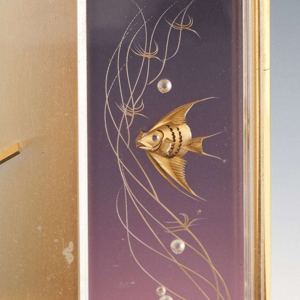 Mid century mantel clock by Jaeger-LeCoultre with brass fish decoration and a central square dial with a skeletonised 8 day movement
