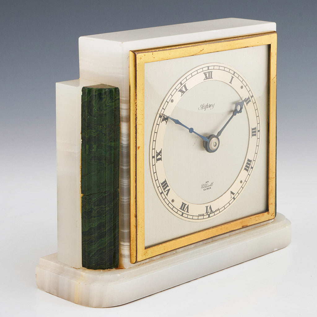 An Art Deco mantel clock by Asprey made of white marbled onyx and green bevelled malachite with a square clock face featuring roman numerals framed with brass