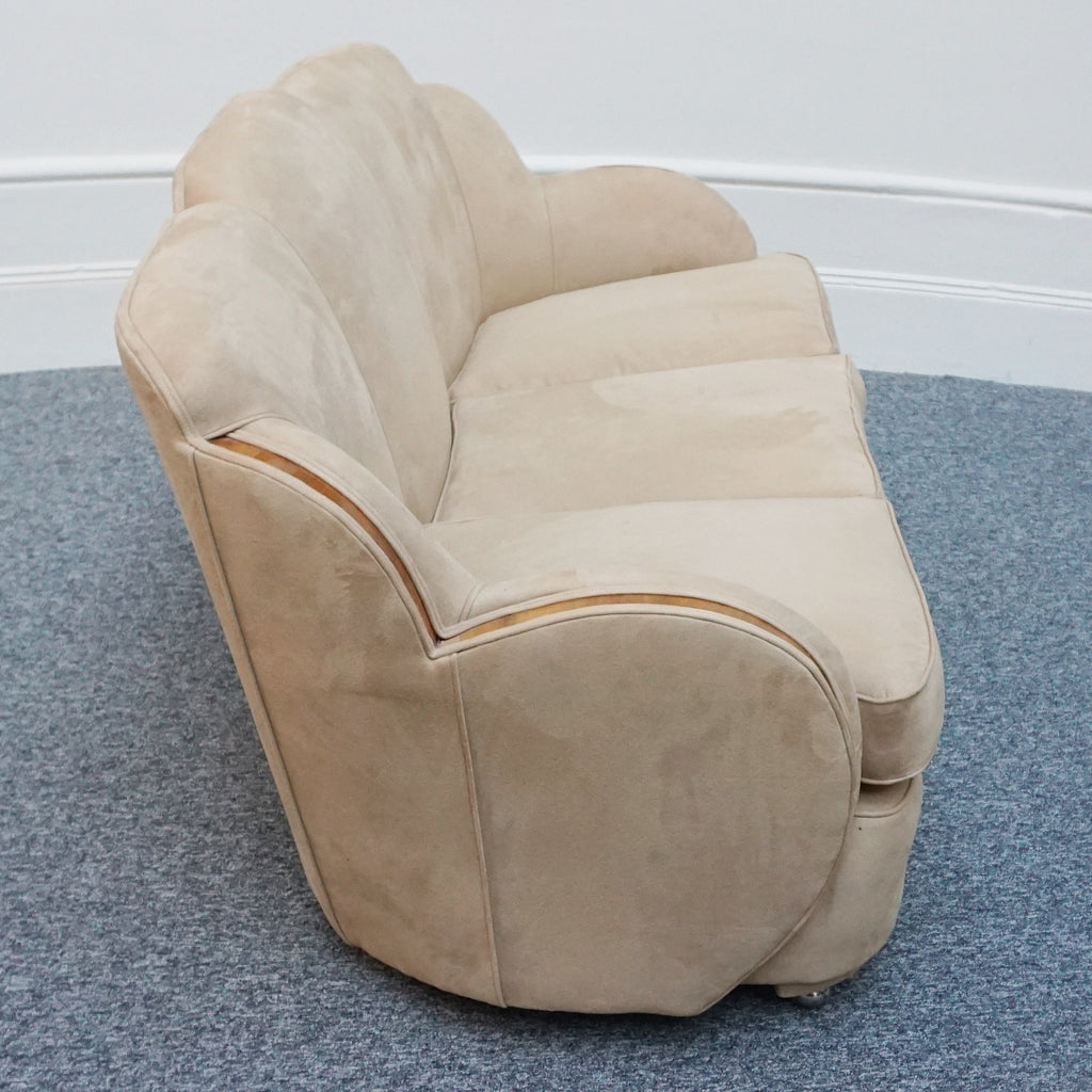 An Art Deco cloud back sofa by Harry & Lou Epstein with figured walnut banding to the arms and upholstered in cream faux suede