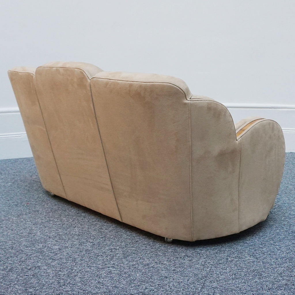 An Art Deco cloud back sofa by Harry & Lou Epstein with figured walnut banding to the arms and upholstered in cream faux suede