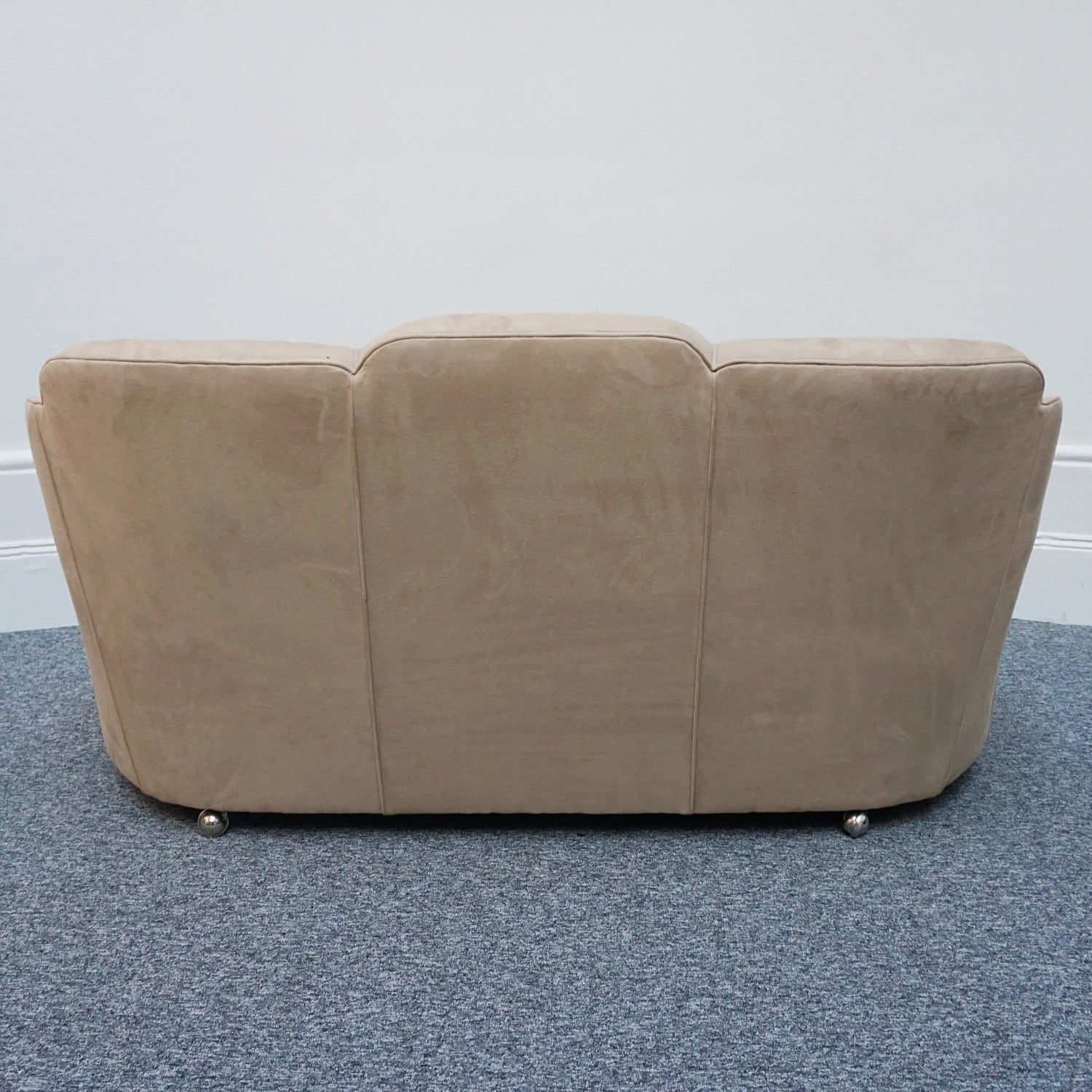 An Art Deco cloud back sofa by Harry & Lou Epstein with figured walnut banding to the arms and upholstered in cream faux suede