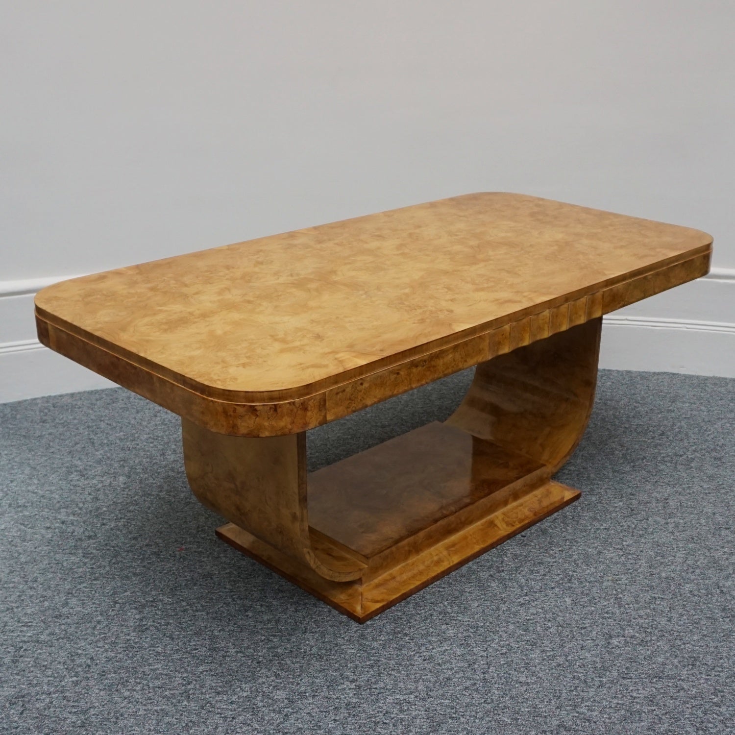 An Art Deco dining table by Harry & Lou Epstein. The table top is burr walnut veneered. 