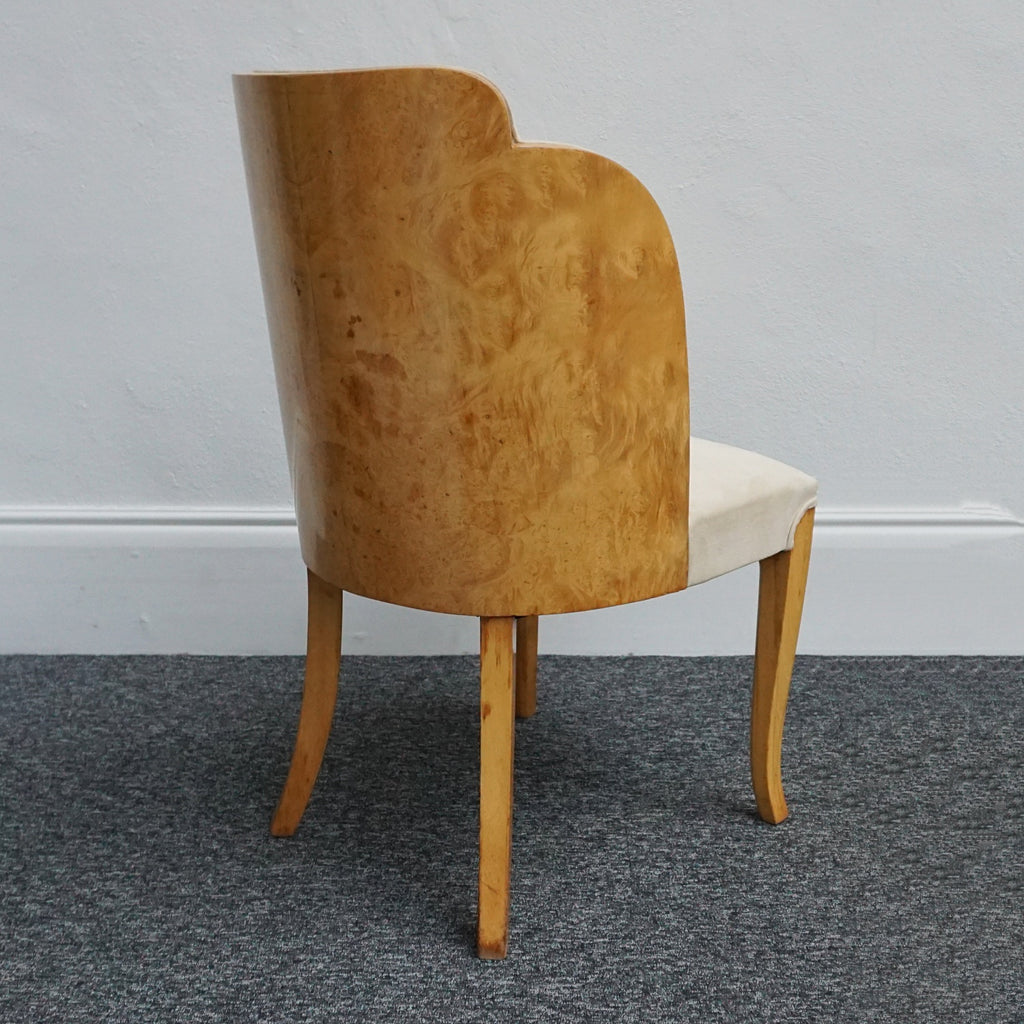 An art deco dining table with 6 chairs by Harry & Lou Epstein. The table top and cloud back armchairs are veneered in burr walnut. The chairs are upholstered in cream faux suede. 