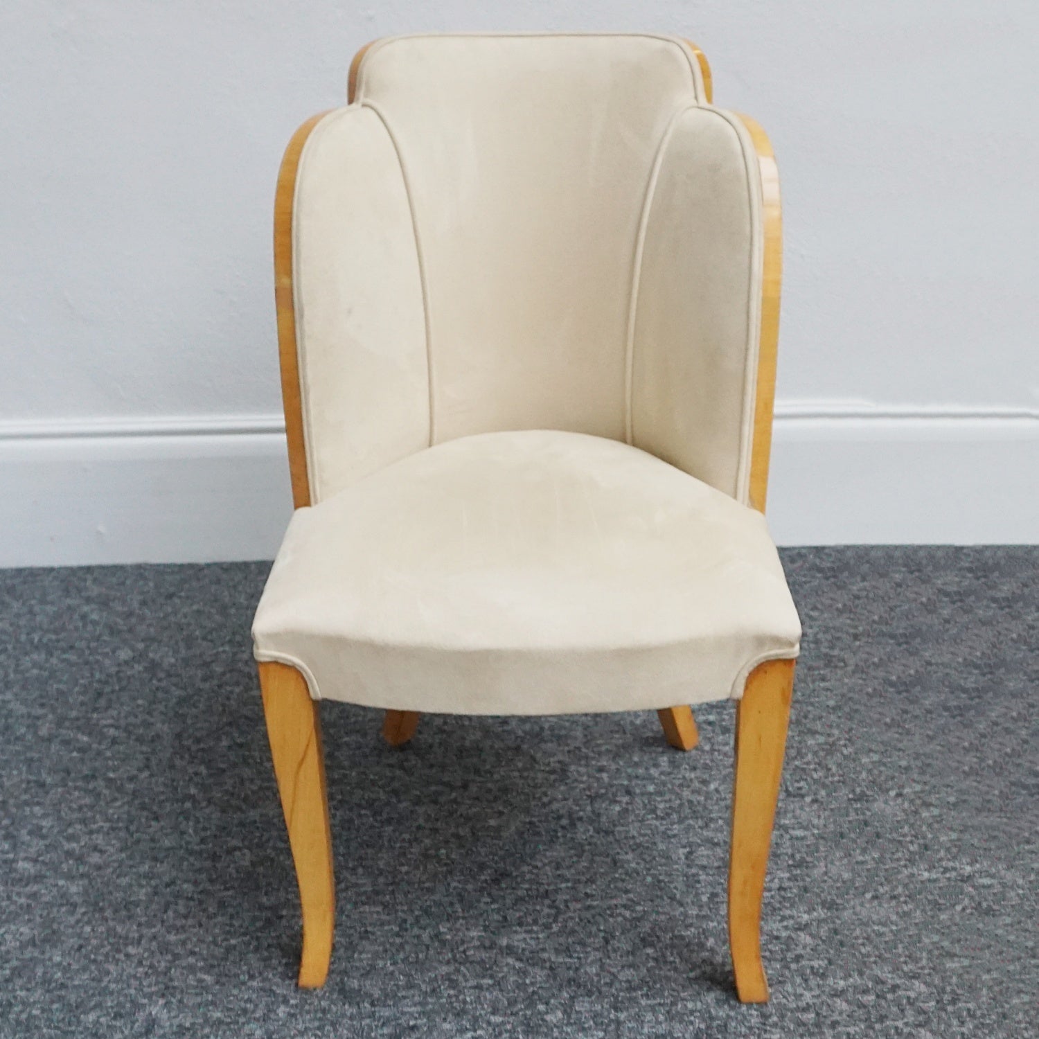 An art deco dining table with 6 chairs by Harry & Lou Epstein. The table top and cloud back armchairs are veneered in burr walnut. The chairs are upholstered in cream faux suede. 