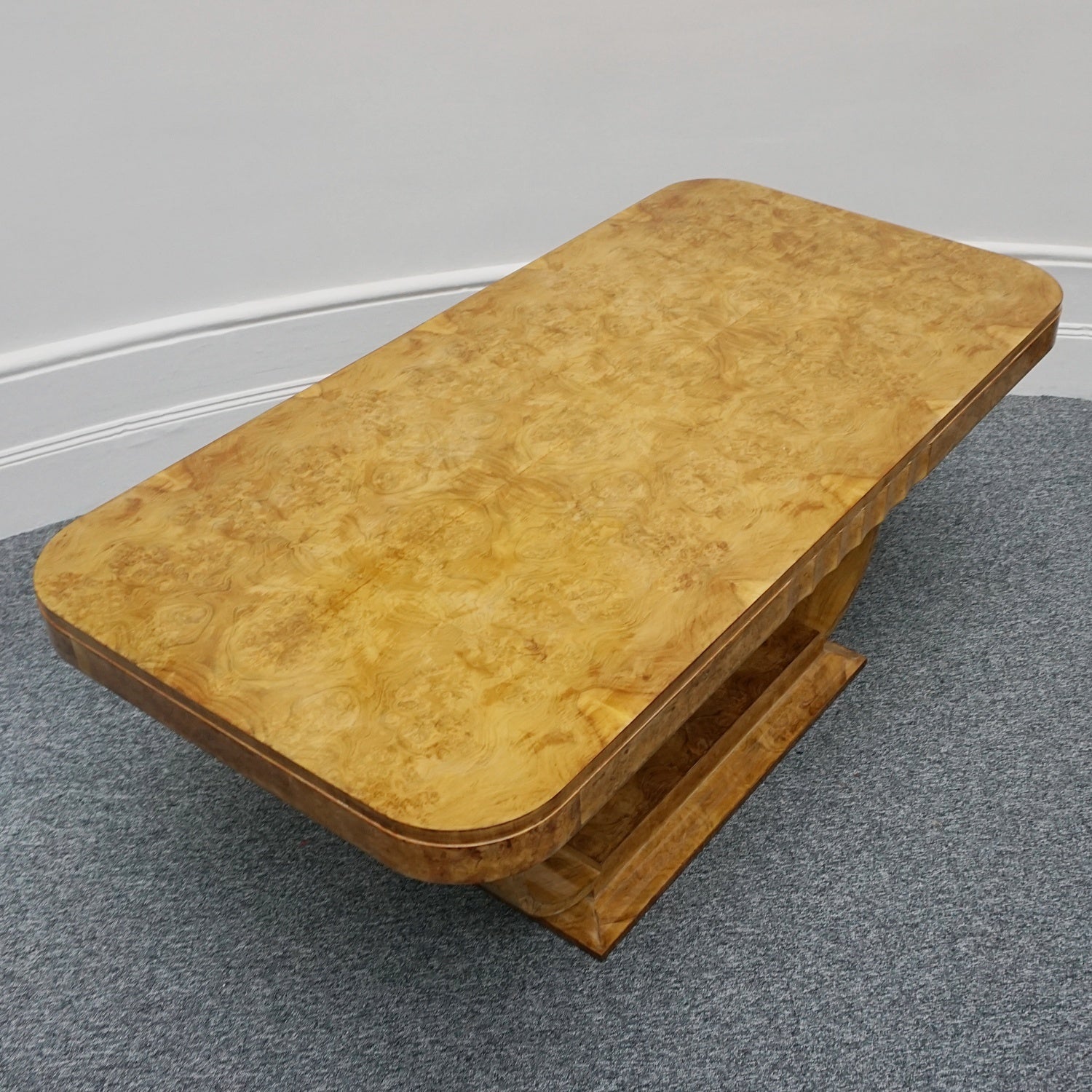 An Art Deco dining table by Harry & Lou Epstein. The table top is burr walnut veneered. 