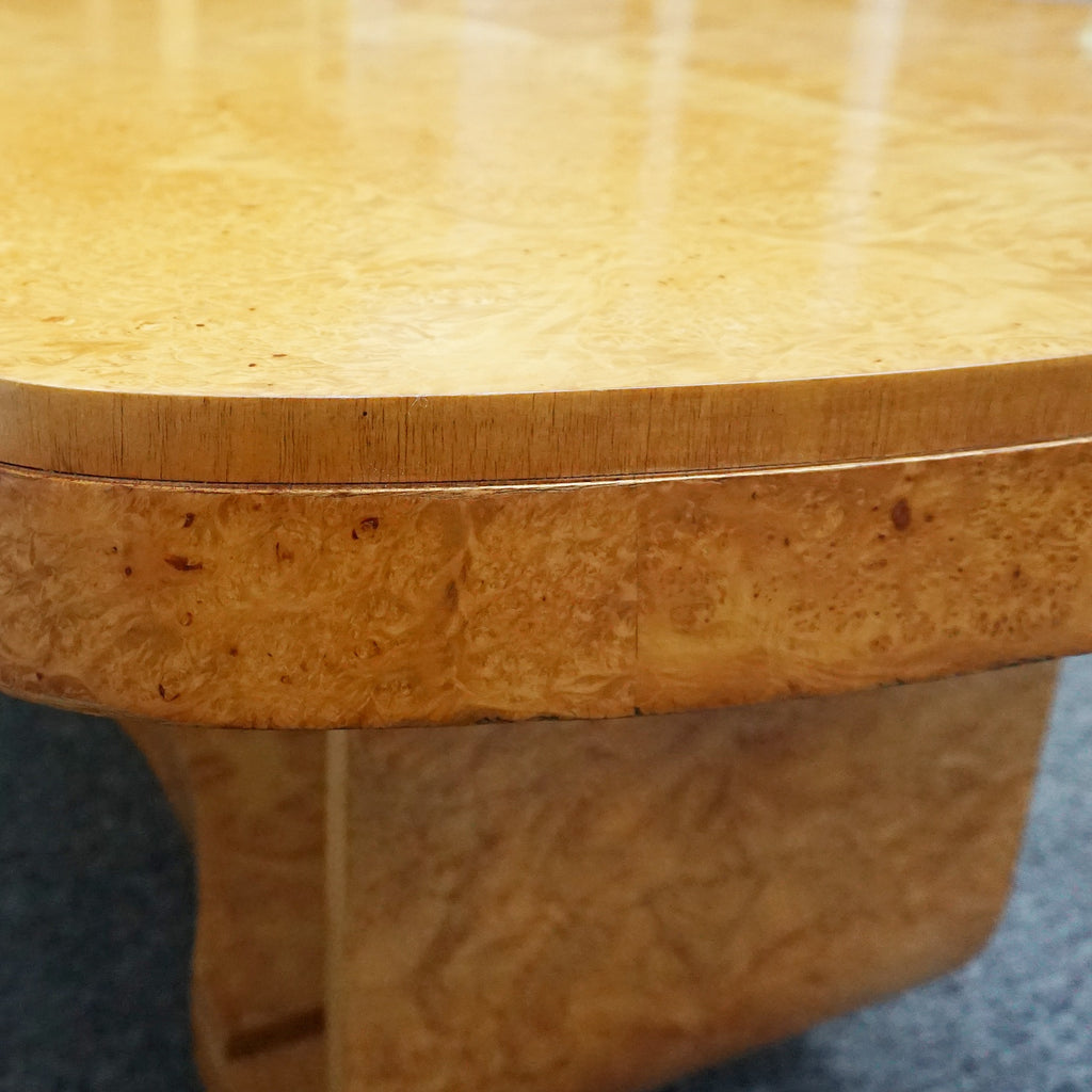 An art deco dining table with 6 chairs by Harry & Lou Epstein. The table top and cloud back armchairs are veneered in burr walnut. The chairs are upholstered in cream faux suede. 