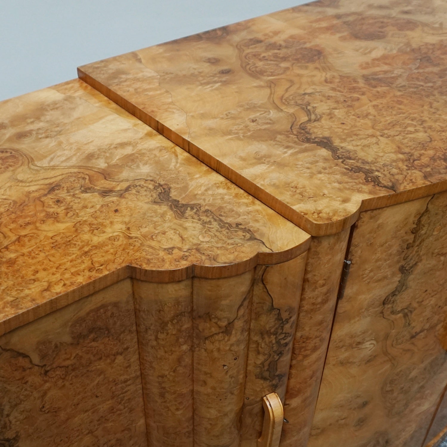 An Art Deco Sideboard by Harry & Lou Epstein with fluted sides set over a curved walnut base made of solid mahogany with burr walnut veneer