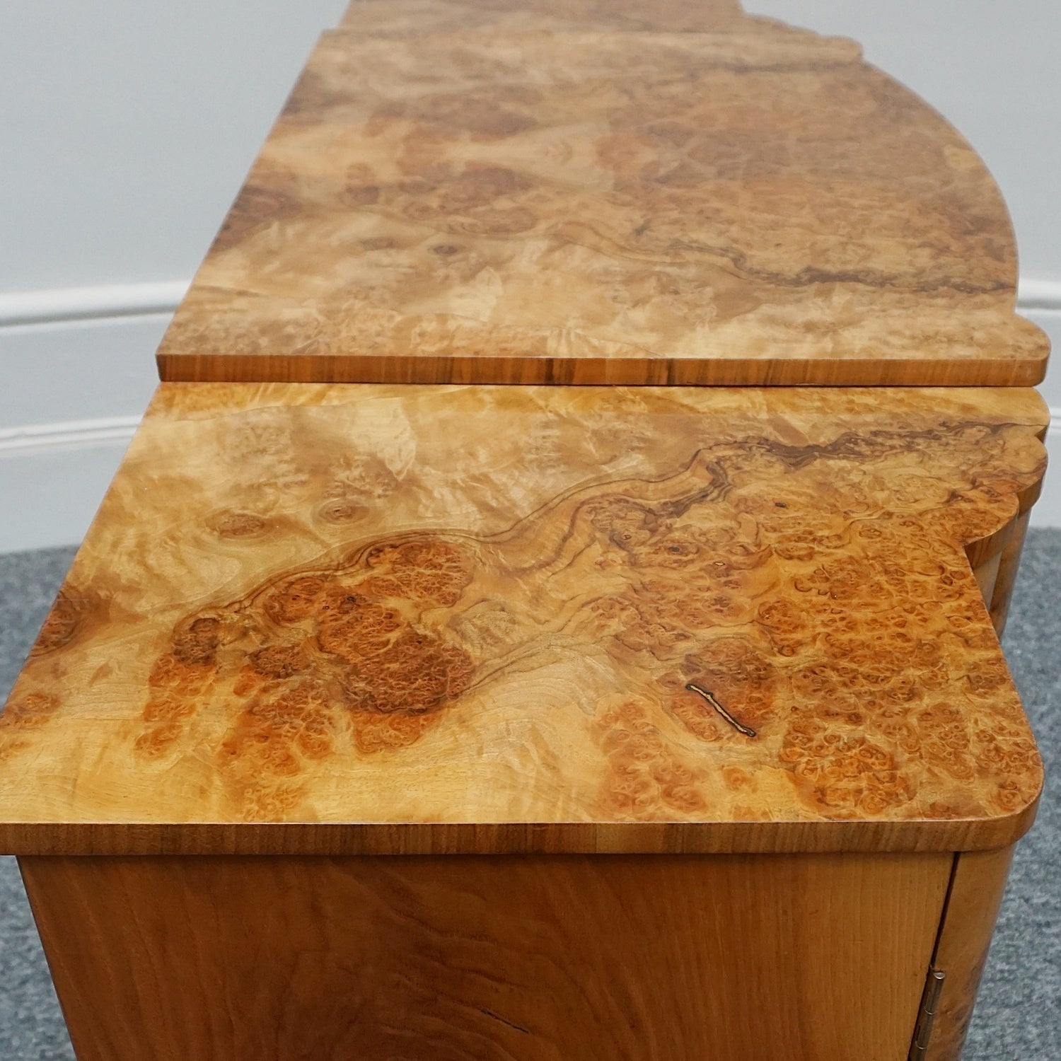 An Art Deco Sideboard by Harry & Lou Epstein with fluted sides set over a curved walnut base made of solid mahogany with burr walnut veneer