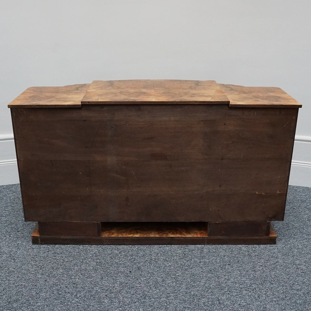 An Art Deco Sideboard by Harry & Lou Epstein with fluted sides set over a curved walnut base made of solid mahogany with burr walnut veneer
