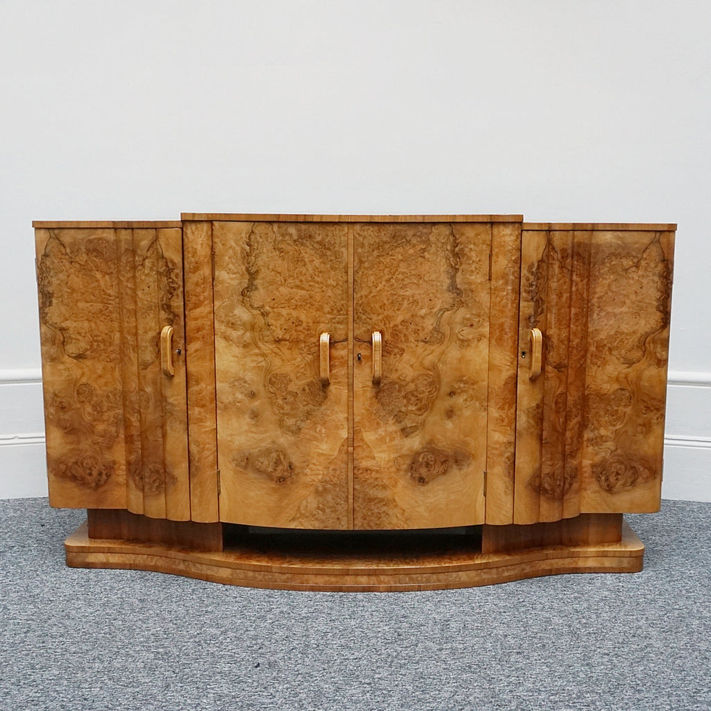 An Art Deco Sideboard by Harry & Lou Epstein with fluted sides set over a curved walnut base made of solid mahogany with burr walnut veneer