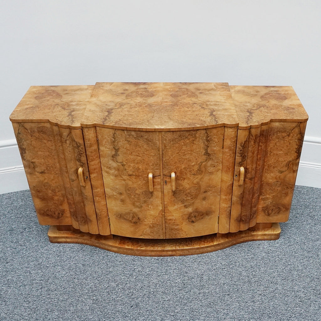 An Art Deco Sideboard by Harry & Lou Epstein with fluted sides set over a curved walnut base made of solid mahogany with burr walnut veneer