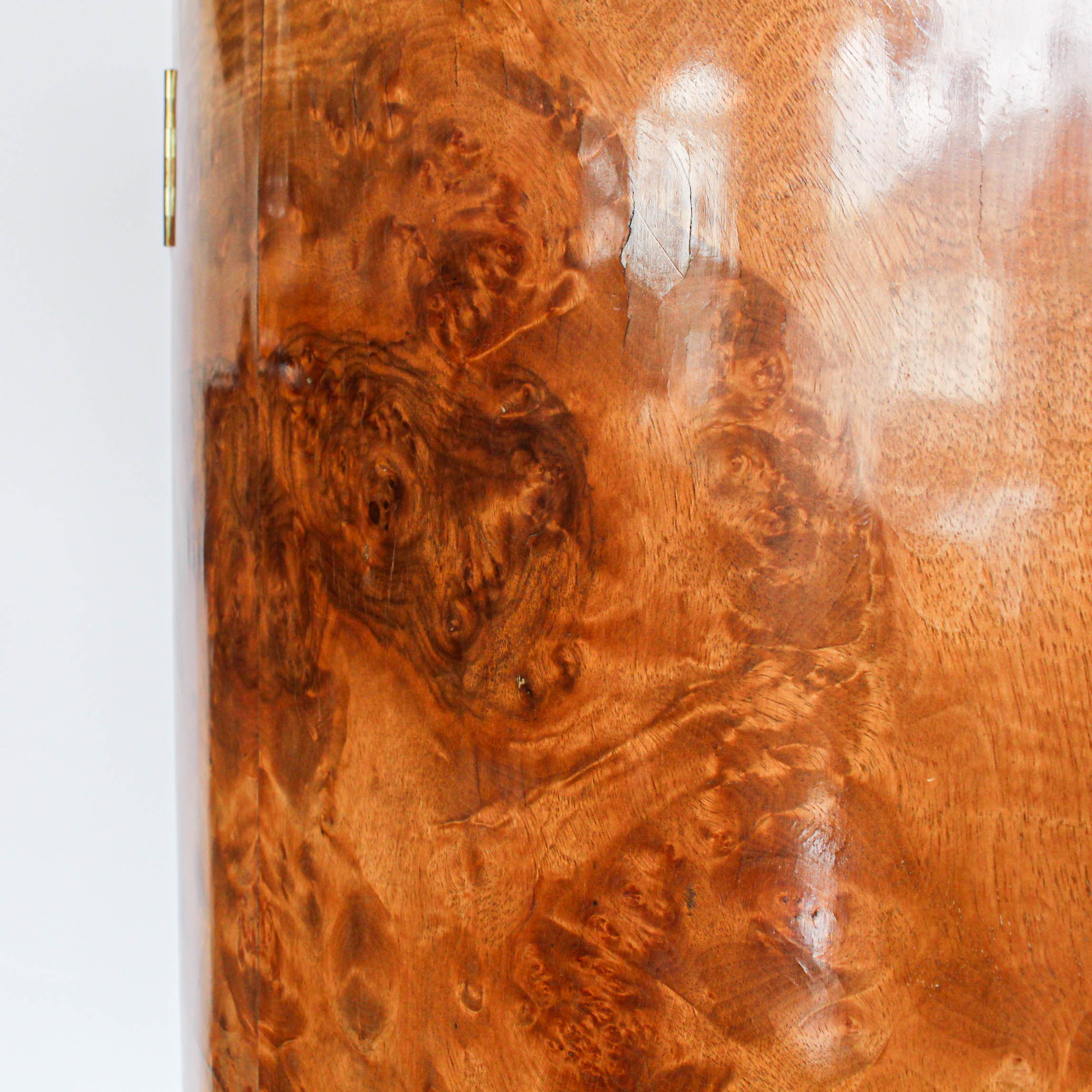 An Art Deco, demi-lune cocktail cabinet attributed to Harry & Lou Epstein. Mirrored, lit interior to top with glass shelves and mirrored slide tray. Lower, shelved cabinet with bottle holders. Burr walnut veneer at Jeroen Markies.