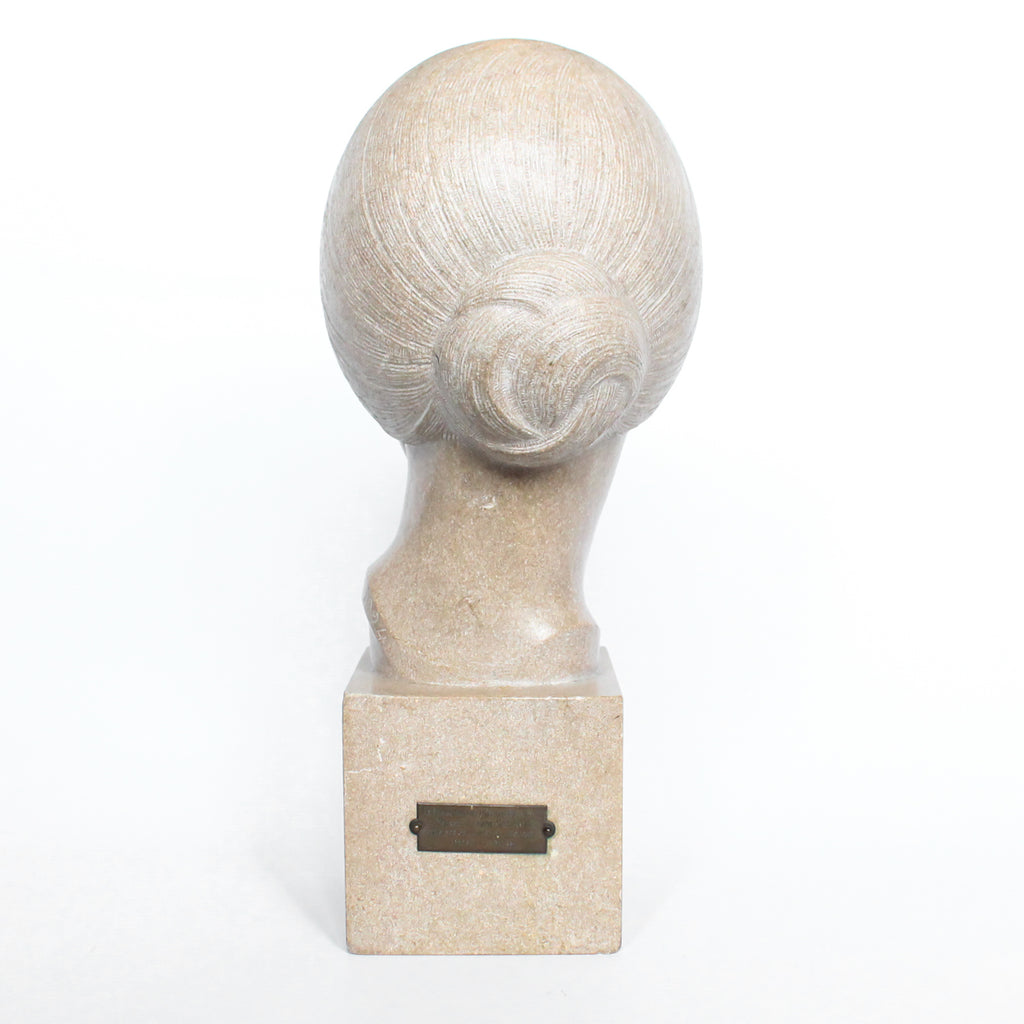 An Art Deco, stone carved sculpture of a smiling young lady, set over an integral plinth. Original dedication plaque to rear at Jeroen Markies.