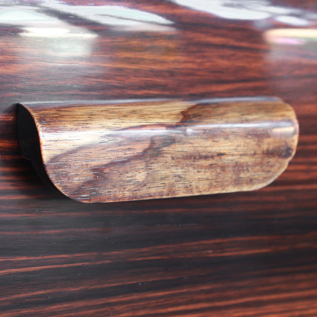 An Art Deco serving/drinks trolley with mirrored top. Double ice-box to one side with drinks cabinet to opposite side, including lower compartment for glasses. Macassar ebony throughout with walnut banding. Original chrome handle and rolling castors.