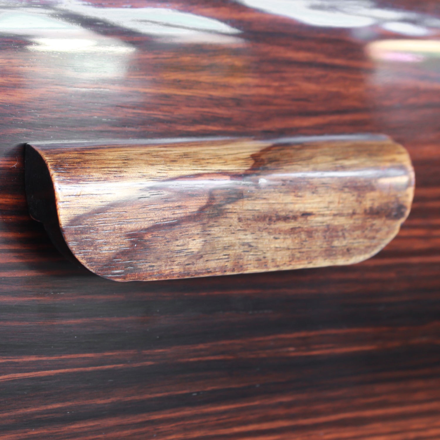 An Art Deco serving/drinks trolley with mirrored top. Double ice-box to one side with drinks cabinet to opposite side, including lower compartment for glasses. Macassar ebony throughout with walnut banding. Original chrome handle and rolling castors.