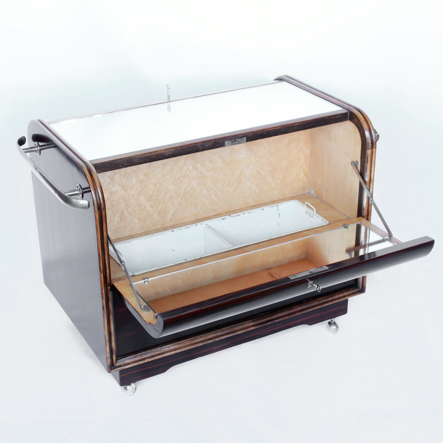 An Art Deco serving/drinks trolley with mirrored top. Double ice-box to one side with drinks cabinet to opposite side, including lower compartment for glasses. Macassar ebony throughout with walnut banding. Original chrome handle and rolling castors.