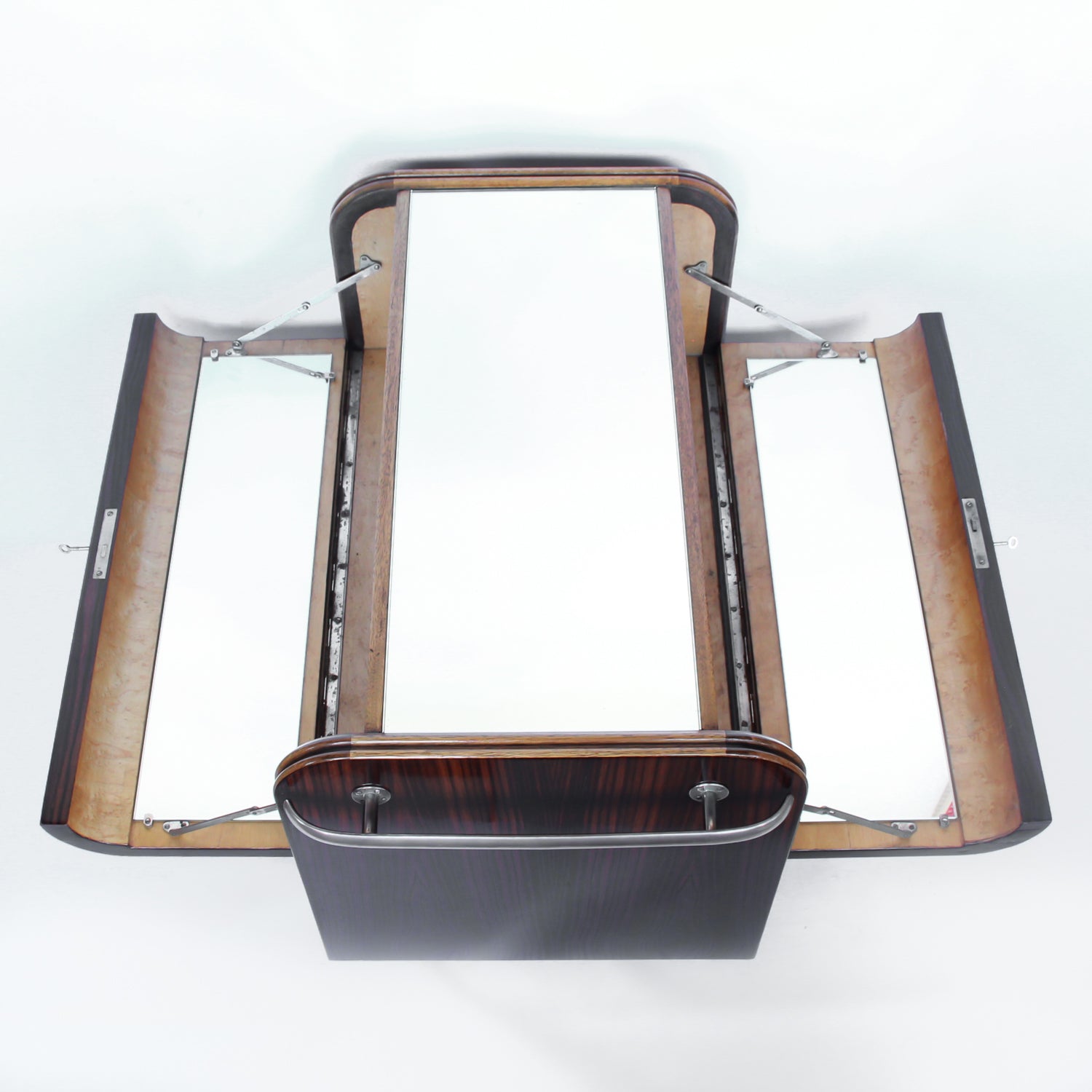 An Art Deco serving/drinks trolley with mirrored top. Double ice-box to one side with drinks cabinet to opposite side, including lower compartment for glasses. Macassar ebony throughout with walnut banding. Original chrome handle and rolling castors.