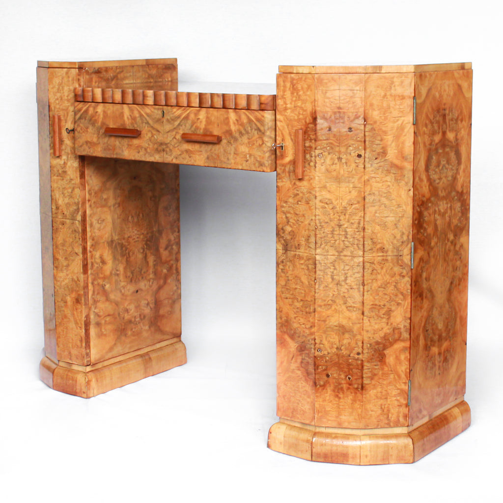 An Art Deco console sideboard by Hille. Burr walnut veneer throughout. Scallop-edged detail to front with integral drawer. Shelved cabinets to either side.