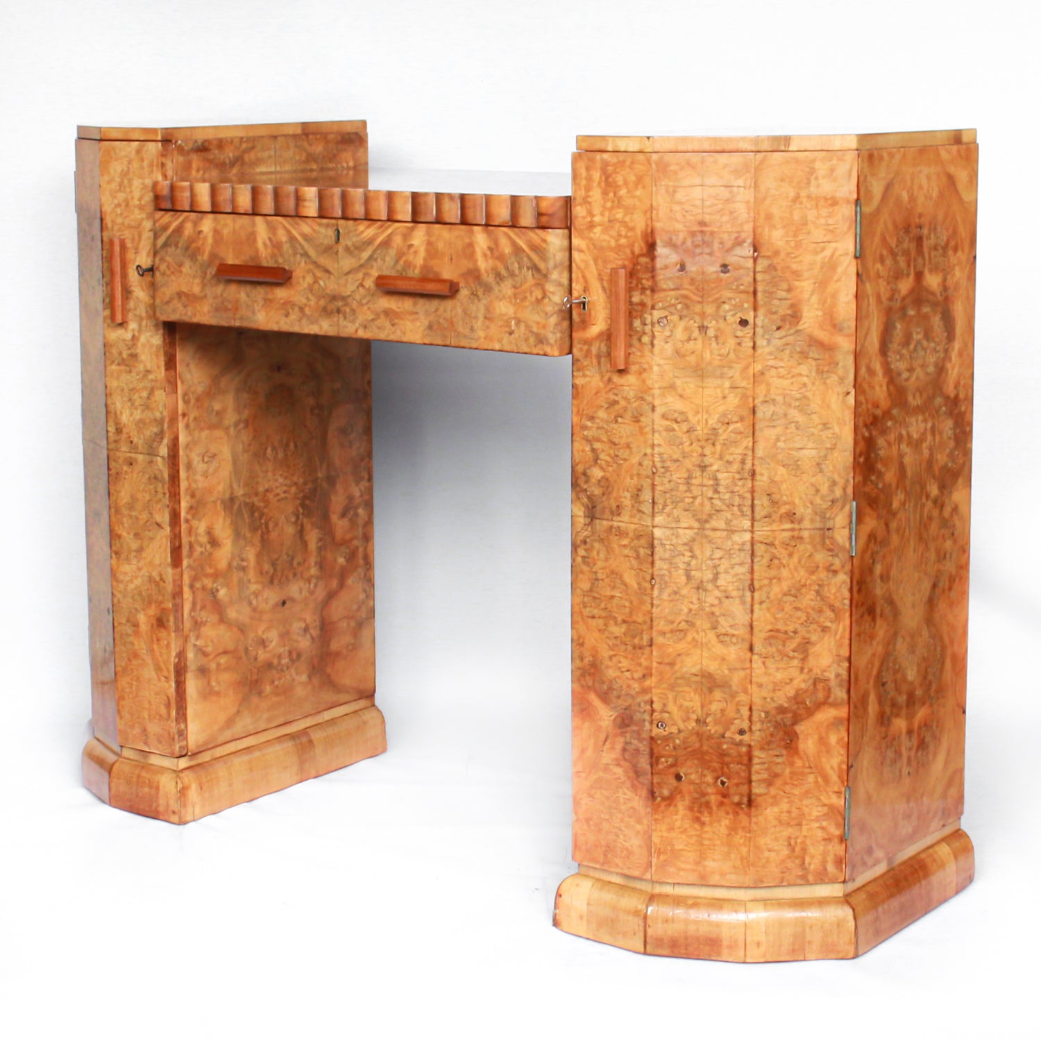An Art Deco console sideboard by Hille. Burr walnut veneer throughout. Scallop-edged detail to front with integral drawer. Shelved cabinets to either side.