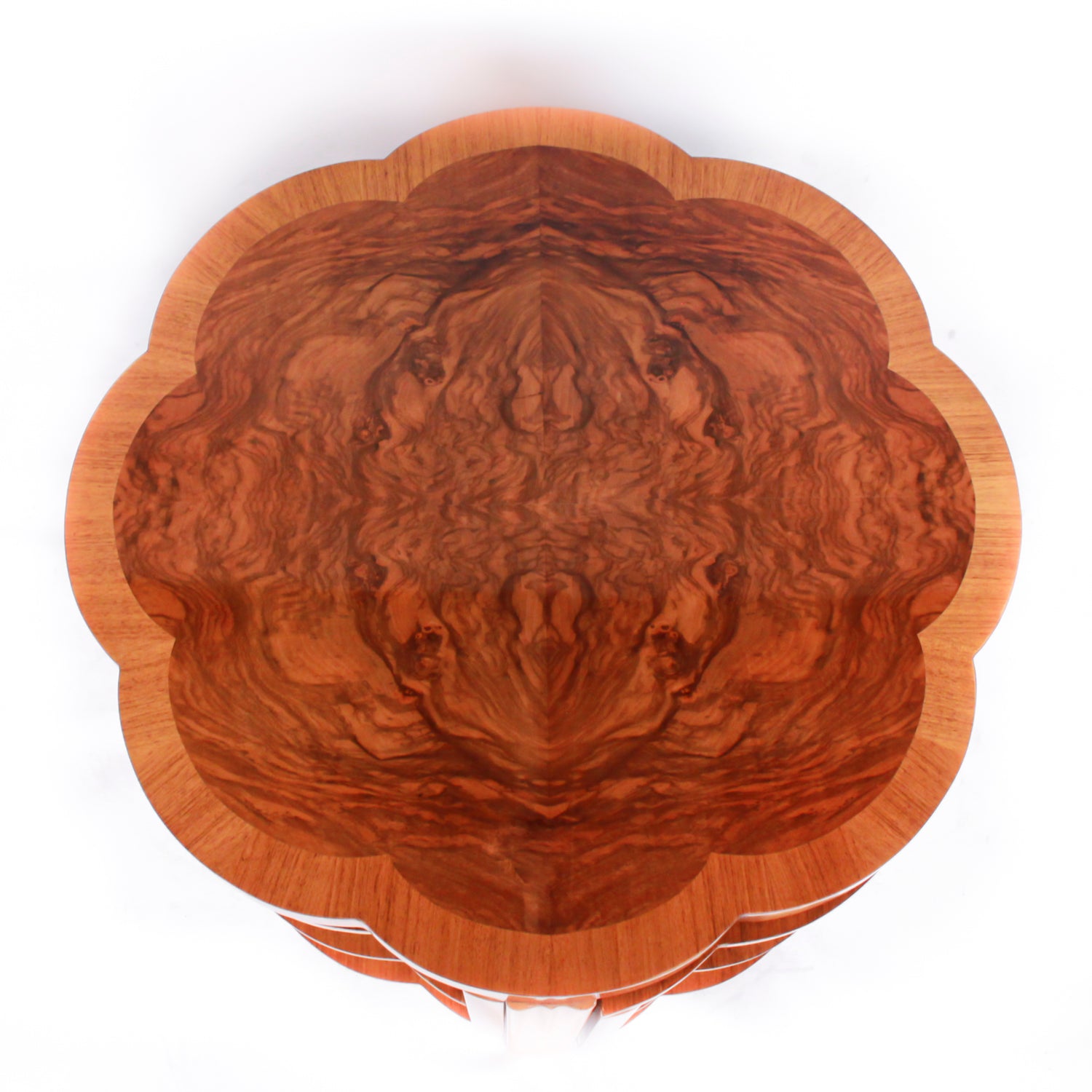 An Art Deco nest of tables in figured and straight grain walnut veneer. Main table with shaped edging set over cross footed base. Four shelved, integral side tables.