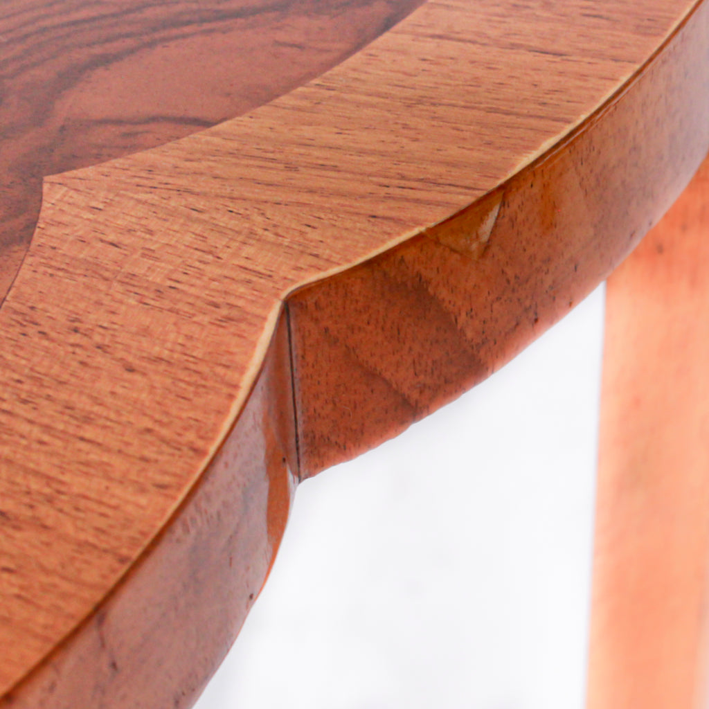 An Art Deco nest of tables in figured and straight grain walnut veneer. Main table with shaped edging set over cross footed base. Four shelved, integral side tables.