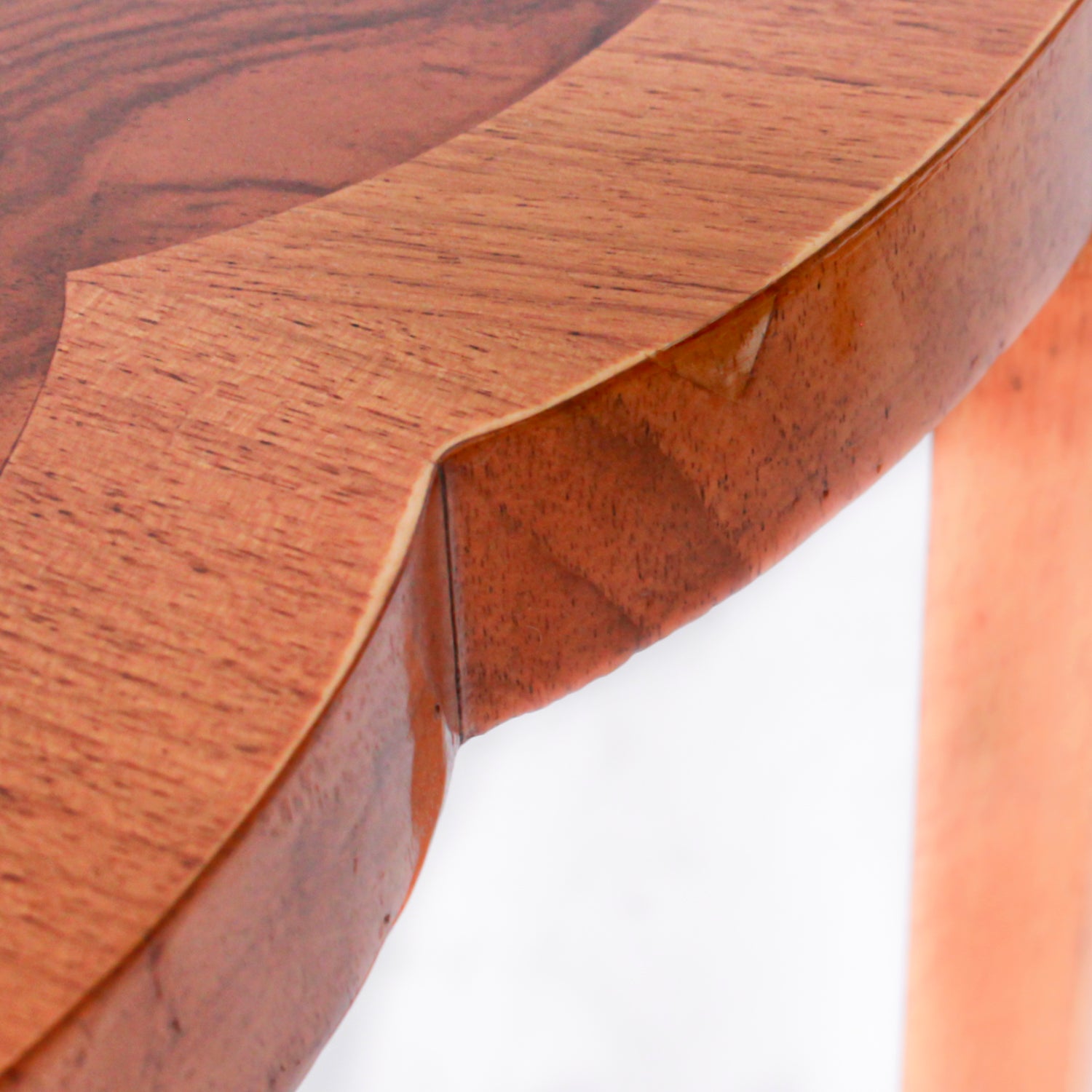 An Art Deco nest of tables in figured and straight grain walnut veneer. Main table with shaped edging set over cross footed base. Four shelved, integral side tables.