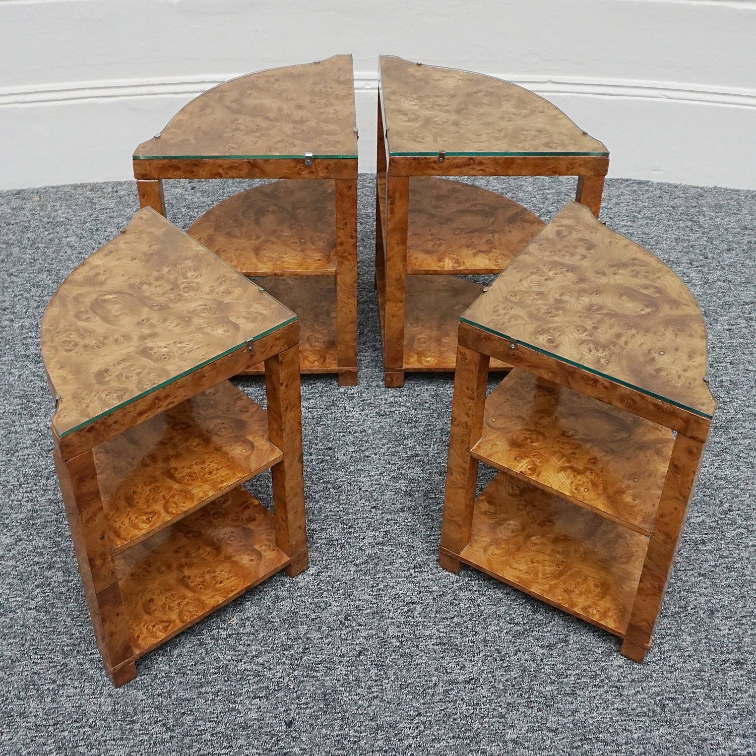 An Art Deco nest of tables by Harry & Lou Epstein Burr walnut veneered. Consisting of a central coffee table with four shelved pull out side tables. The tables have glass tops.