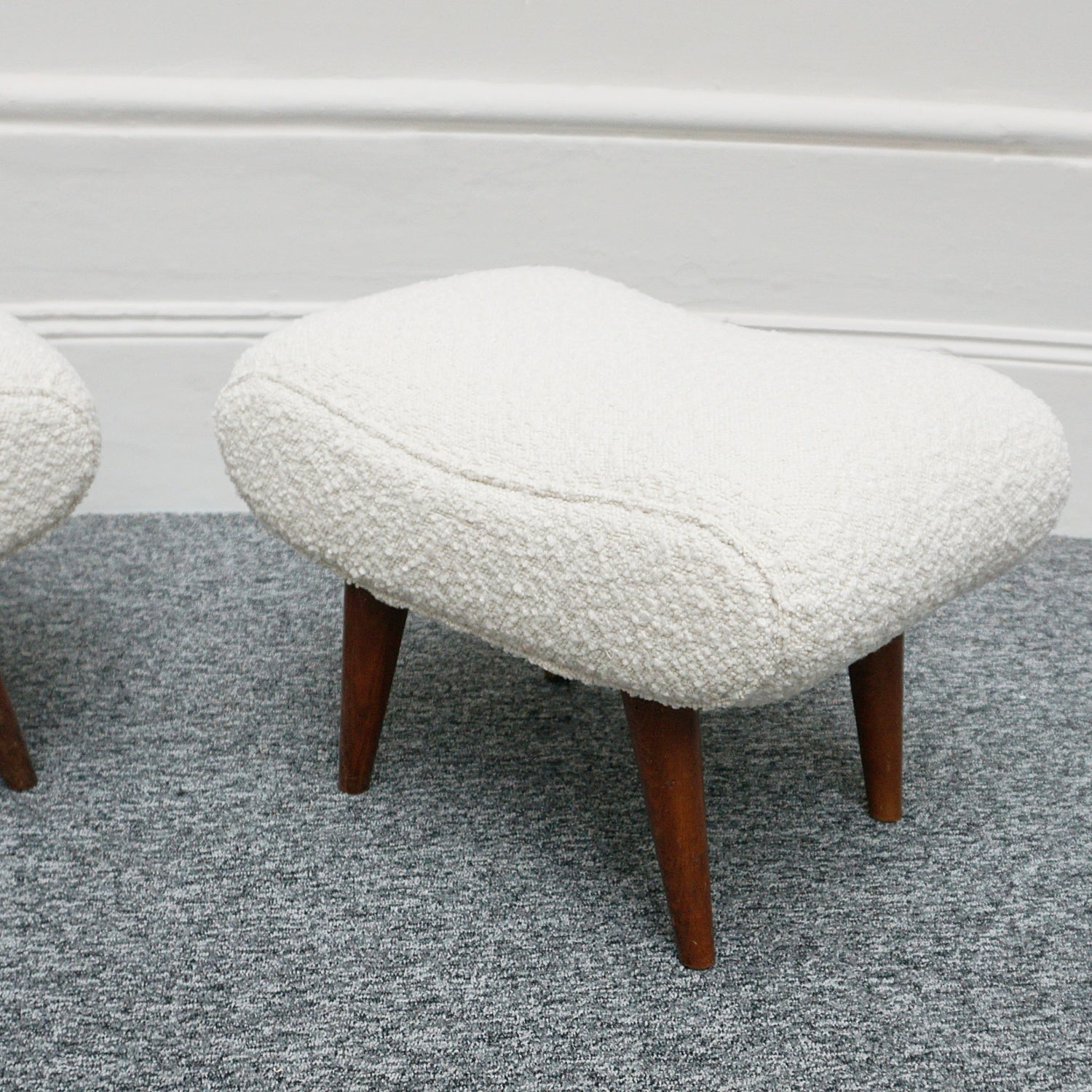  A Pair of Mid Century Footstools  re-upholstered in white Bouclé with tapered teak feet