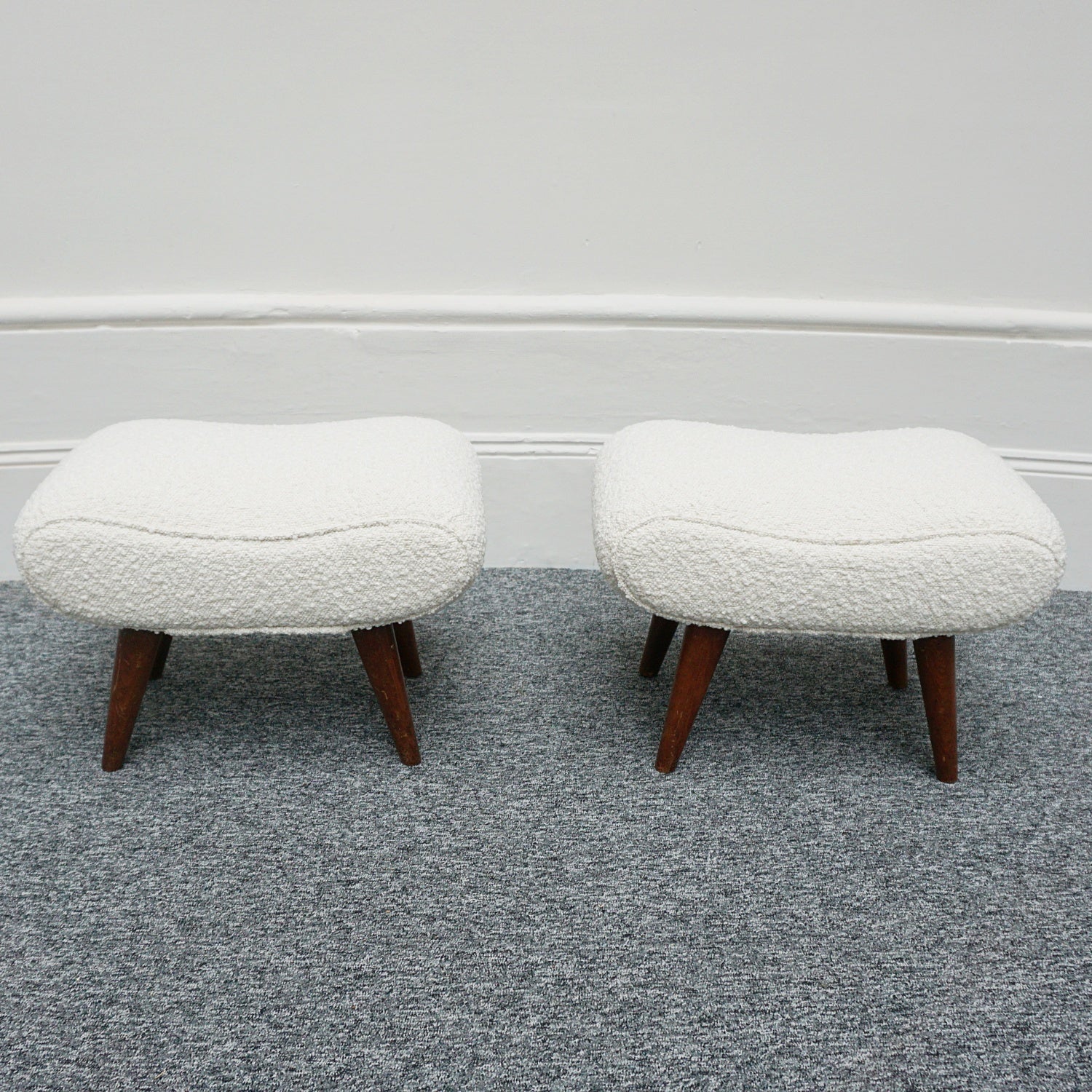  A Pair of Mid Century Footstools  re-upholstered in white Bouclé with tapered teak feet