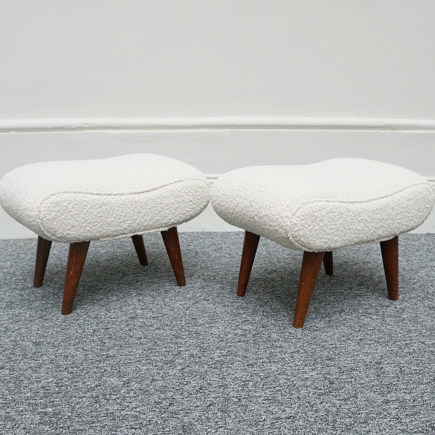  A Pair of Mid Century Footstools  re-upholstered in white Bouclé with tapered teak feet