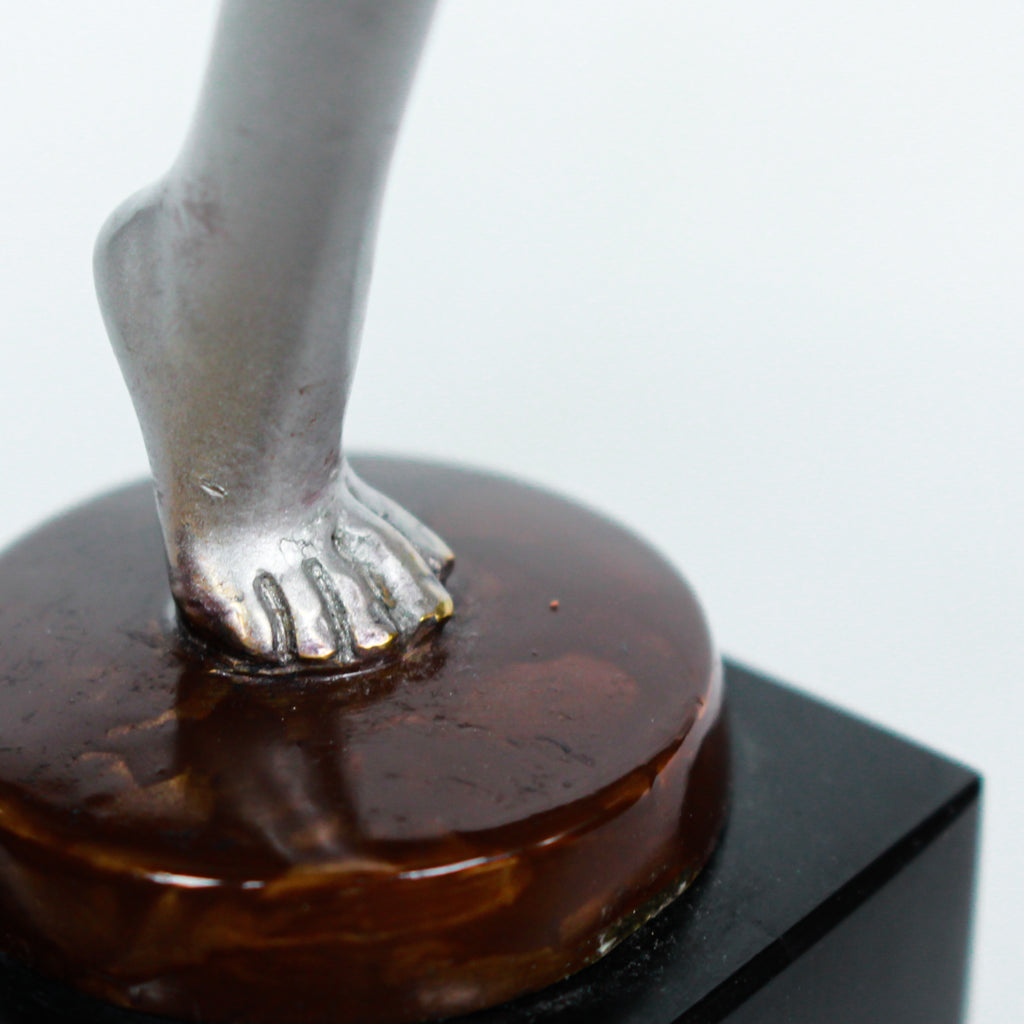 An Art Deco, cold painted bronze figure of an elegant dancer holding a tambourine, raised on a green onyx base.  Signed Lorenzl to bronze